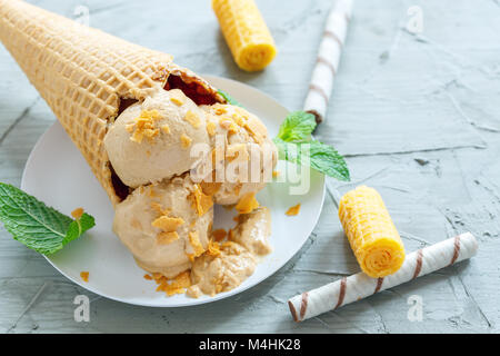 Cornet gaufré avec crème glacée au caramel. Banque D'Images