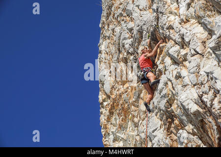 NAPLES , ITALIE -04 septembre 2017 : une femme athlétique et monte une montagne près de la mer sur une chaude journée d'été .mise à l'échelle du visage de roche est un sport pratiqué par de nombreuses personnes Banque D'Images