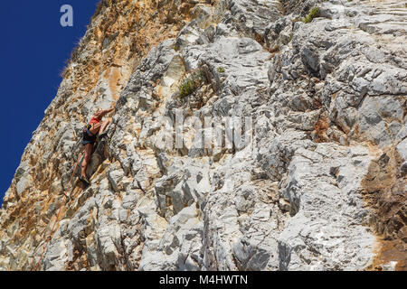 NAPLES , ITALIE -04 septembre 2017 : une femme athlétique et monte une montagne près de la mer sur une chaude journée d'été .mise à l'échelle du visage de roche est un sport pratiqué par de nombreuses personnes Banque D'Images