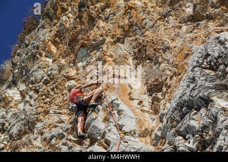 NAPLES , ITALIE -04 septembre 2017 : une femme athlétique et monte une montagne près de la mer sur une chaude journée d'été .mise à l'échelle du visage de roche est un sport pratiqué par de nombreuses personnes Banque D'Images