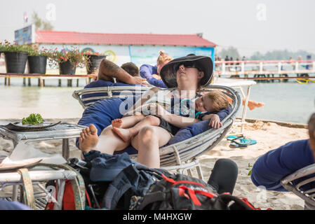 Les touristes dort dans un fauteuil à l'un des bars de plage en plage de Sihanoukville, Cambodge Banque D'Images