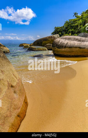 Plage déserte entre les rochers et la forêt tropicale Banque D'Images