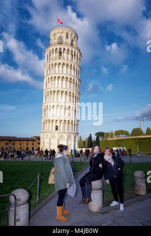 Pise, Italie - Février 11, 2018 : Deux jeunes filles posent pour une photo avec la célèbre Tour de Pise en arrière-plan, sur la Piazza dei Miracoli. Banque D'Images