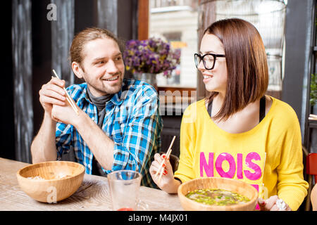 Les amis de manger les repas au restaurant asiatique Banque D'Images