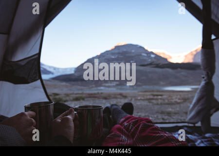 Couple having coffee in tent Banque D'Images