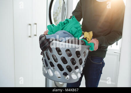 Man holding panier de vêtements blanchisserie Banque D'Images