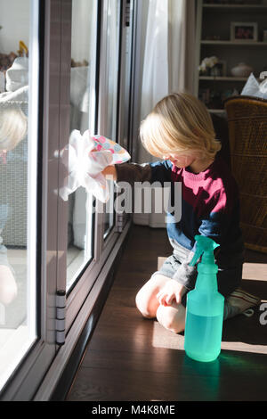 Garçon avec fenêtre nettoyage chiffon rag Banque D'Images