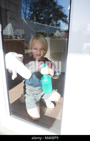 Garçon avec fenêtre nettoyage chiffon rag Banque D'Images