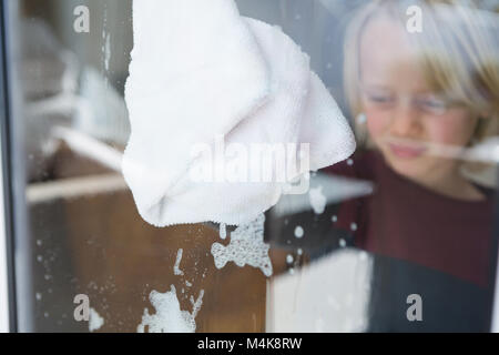 Garçon avec fenêtre nettoyage chiffon rag Banque D'Images