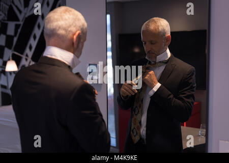 Businessman tying sa cravate devant un miroir Banque D'Images