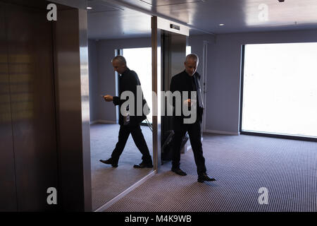 Businessman walking out l'ascenseur Banque D'Images