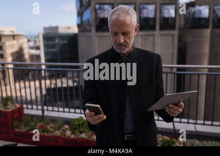 Businessman using mobile phone and laptop Banque D'Images