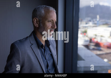 L'homme d'affaires à l'extérieur de la fenêtre Banque D'Images