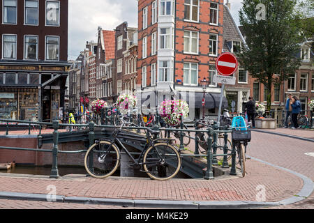 Coin de rue typique d'Amsterdam montrant des vélos, vente au détail, du canal et les bâtiments résidentiels, Banque D'Images