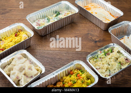 Plats à emporter dans des contenants d'aluminium sur la table en bois Banque D'Images