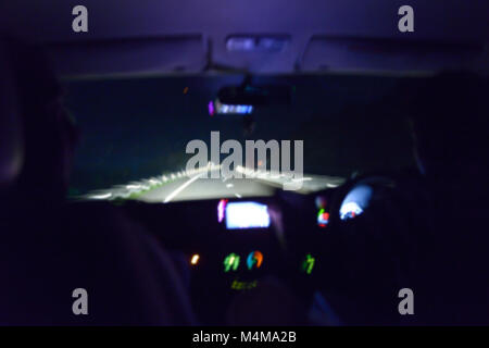 L'intérieur de la nuit photo floue voiture avec chauffeur. Vue sur l'autoroute. Banque D'Images