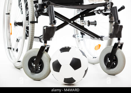 Fauteuil roulant pour personne handicapée ou invalide et soccer ball Banque D'Images