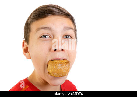 Young caucasian teenage boy eating a pork pie Banque D'Images