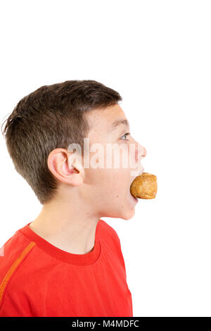 Young caucasian teenage boy eating a pork pie Banque D'Images