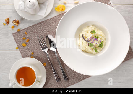 Bouillie de riz dans une assiette blanche sur fond de bois blanc Banque D'Images