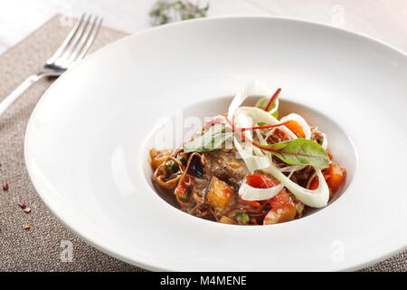 Salade de légumes cuits sur fond de bois blanc Banque D'Images
