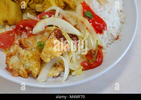 Salade épicée avec des oeufs frits et poulet au curry sur le riz Banque D'Images