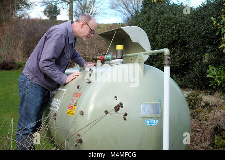 Calor Gas male customer lecture de la jauge du compteur dans un établissement rural UK Banque D'Images