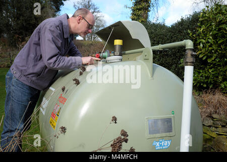 Calor Gas male customer lecture de la jauge du compteur dans un établissement rural UK Banque D'Images