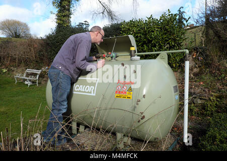 Calor Gas male customer lecture de la jauge du compteur dans un établissement rural UK Banque D'Images