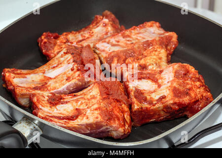 Côtes de porc assaisonnées dans la poêle de cuisson, Banque D'Images