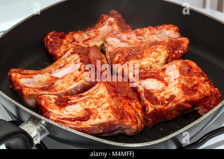 Côtes de porc assaisonnées dans la poêle de cuisson, Banque D'Images