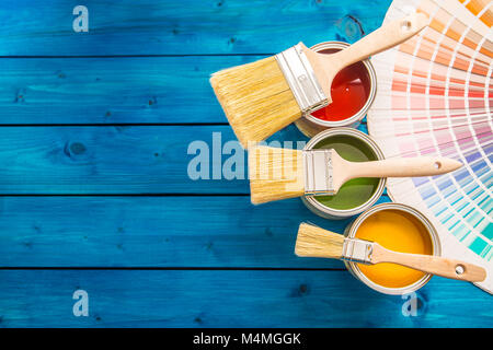 Palette de couleurs des pots de peinture, bidons ouverts avec des brosses à tableau bleu. Banque D'Images