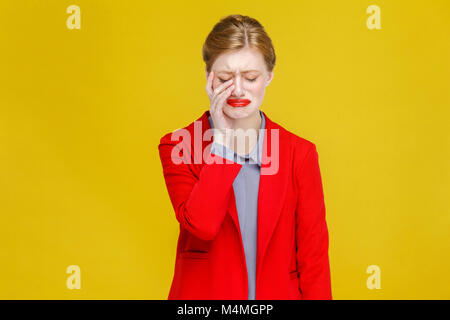 Ginger red head business woman in red suit la douleur de dent. Studio shot, isolé sur fond jaune Banque D'Images