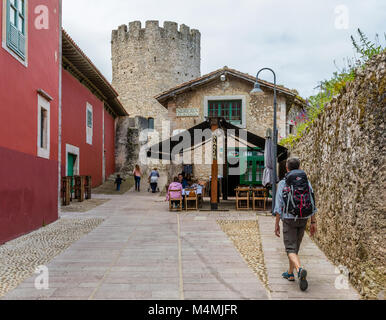 Sac à dos femme marche vers une Sidreria ou cider house et le château dans la ville de Llanes, dans les Asturies au nord de l'Espagne Banque D'Images