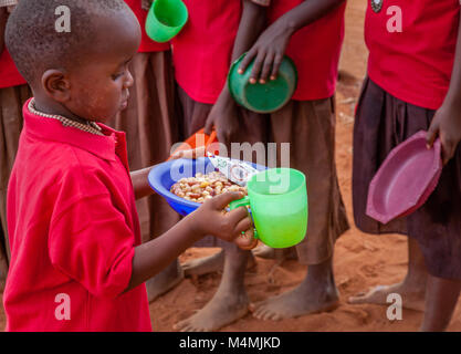 Enfant de l'école avec son ragoût de haricots à l'heure du déjeuner avec le maïs et les oignons à l'école primaire Kileva près de vi dans le sud du Kenya Banque D'Images