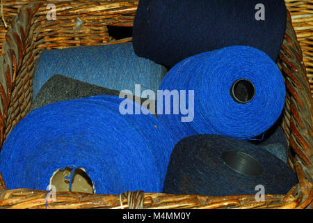 Les grandes bobines de fil bleu dans un panier en osier Banque D'Images