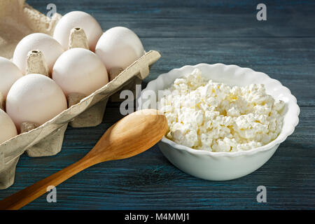 Le fromage blanc et les oeufs sur fond de bois bleu Banque D'Images