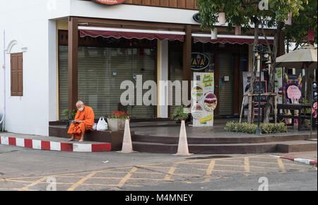 CHIANG MAI, THAÏLANDE - 29 janvier 2018 ; Moine en robe safran portant un masque chirurgical avec des sacs de magasinage plstic se situe sur la chaussée à l'extérieur comme angle Banque D'Images