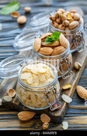 Flocons d'amandes, les amandes et les pistaches en pots. Banque D'Images