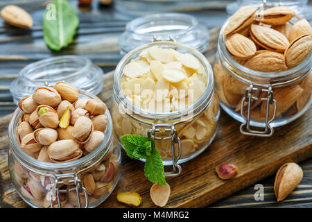 Pistaches, Amandes et flocons d'amandes dans des bocaux en verre. Banque D'Images