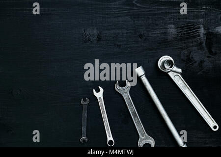 Mise à plat de l'ensemble d'outils pour la réparation automobile tels que clés sur fond de bois noir. Vue d'en haut. Copier l'espace. La vie encore. Mise à plat Banque D'Images