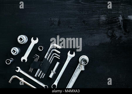 Mise à plat de l'ensemble d'outils pour la réparation automobile tels que clés sur fond de bois noir. Vue d'en haut. Copier l'espace. La vie encore. Mise à plat Banque D'Images