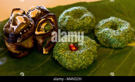 Rouleaux de l'aubergine avec un remplissage de noix, Georgian snack 'phali" d'épinards avec des herbes et des graines de grenade, sur la feuille de chard Banque D'Images