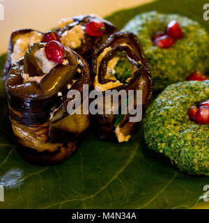 Rouleaux de l'aubergine avec un remplissage de noix, Georgian snack 'pkhali" d'épinards avec des herbes et des graines de grenade, sur la feuille de chard Banque D'Images