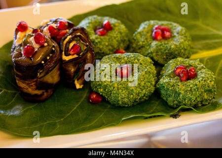 Rouleaux de l'aubergine avec un remplissage de noix, Georgian snack 'pkhali" d'épinards avec des herbes et des graines de grenade, sur la feuille de chard Banque D'Images