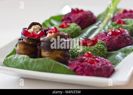 Rouleaux de l'aubergine avec un remplissage de noix, Georgian snack 'pkhali" d'épinards et de betteraves aux herbes et graines de grenade, sur la feuille de chard Banque D'Images