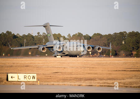 Le pape ARMY AIRFIELD, N.C. - Un C-17 Globemaster III à partir de la 62e Escadre de transport aérien à Joint base McChord, Wash., roule sur la piste ici avec une charge de la 82e Airborne Division de parachutistes et le 9 février, 2018 fret, au cours d'une semaine de gros paquets d'urgence et la disponibilité du déploiement se tiendra du 5 au 11 février. Aviateurs dans le 43d du Groupe des opérations de mobilité aérienne au Pape fourni l'appui au sol pour les équipages de l'Armée de l'air transport aérien de soldats et d'équipement hors du Pape domaine pendant l'exercice. Tout au long de la semaine, les équipes de l'Air Mobility Command effectué 173 missions, transportant plus de 3 000 Indemnité de Banque D'Images