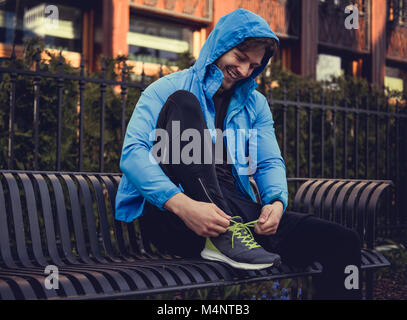 L'homme sportif dans un veston bleu étroits ses baskets. Banque D'Images