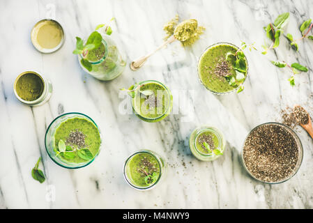 Vert Matcha smoothie vegan avec chia seeds et de menthe fraîche dans les verres et bouteilles en arrière-plan, Vue de dessus. L'alimentation saine, propre, detox diète alcaline Banque D'Images