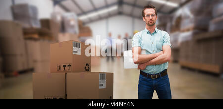 3d composite image of warehouse manager standing with arms crossed Banque D'Images